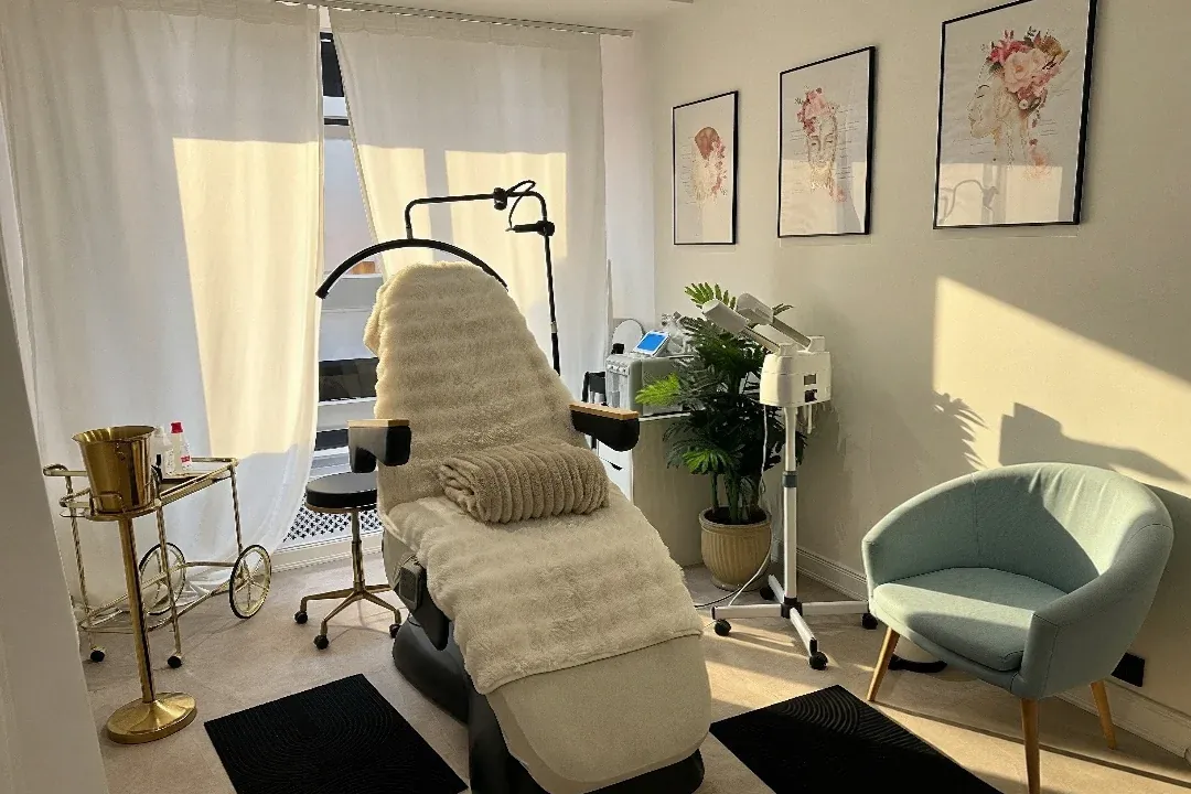 Behandlungsraum im VOILÀ Atelier mit Liege, Pflanzen und Kunst an der Wand